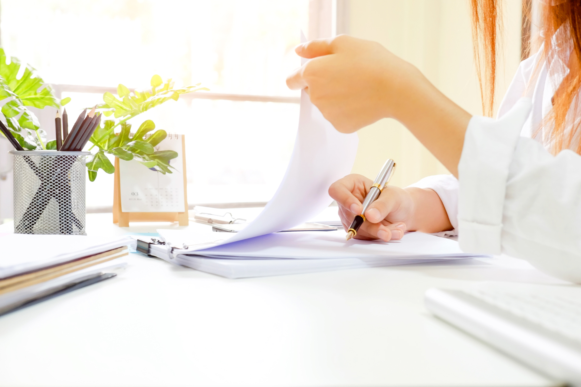 Persona revisando y tomando notas en un informe de una auditoria de accesibilidad.