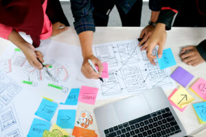 Personas trabajando en el diseño de interfaces accesibles con notas y diagramas sobre la mesa