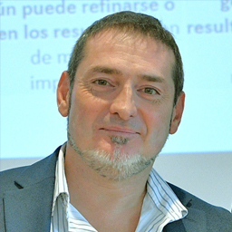 Retrato de Iban Huarte, director de ApnabiLan y del área de vida adulta de Apnabi, sonriendo, con fondo claro y traje gris.