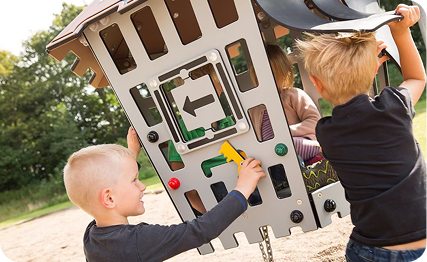 Niños jugando en un parque infantil accesible